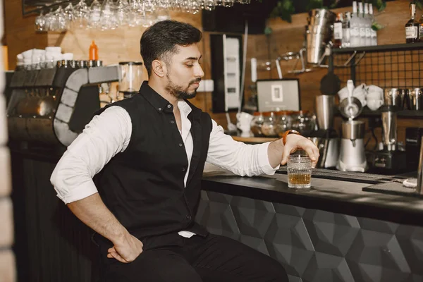 Jóképű férfi a bárban whiskyvel. — Stock Fotó