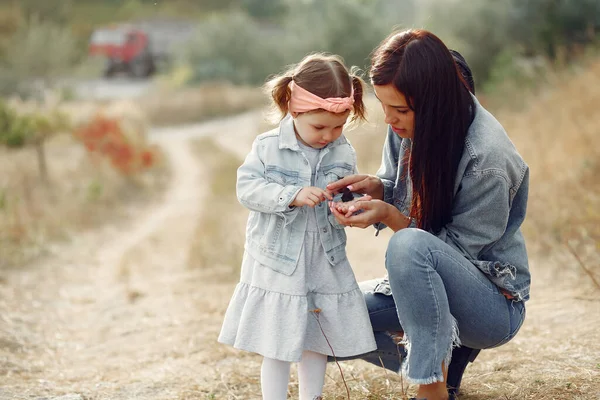 Mãe com filhinha brincando em um campo de outono — Fotografia de Stock