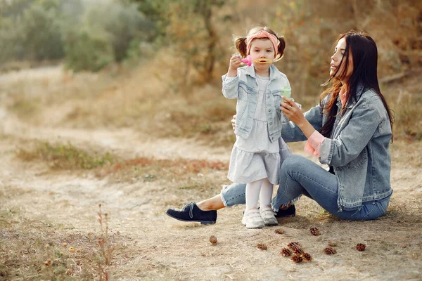 Mãe com filhinha brincando em um campo de outono — Fotografia de Stock