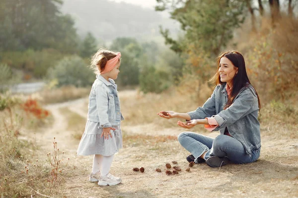 Moeder met dochtertje speelt in een herfstveld — Stockfoto