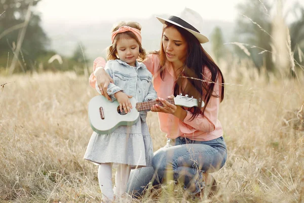 Moeder met dochtertje speelt in een herfstveld — Stockfoto