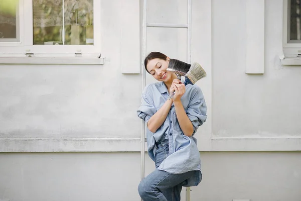 Cute girl standing near wall with repair tools — Stock Photo, Image