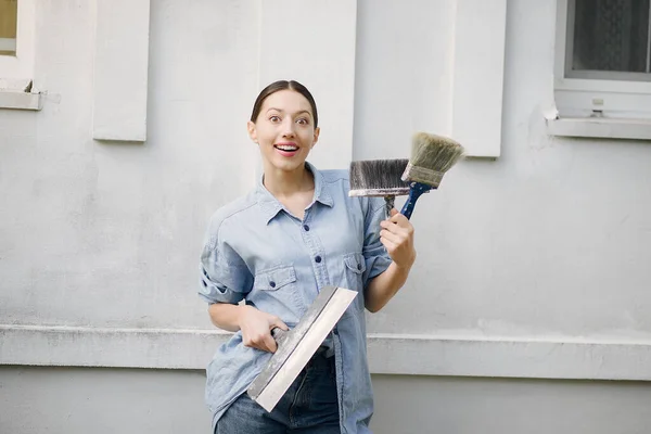 Menina bonito de pé perto da parede com ferramentas de reparo — Fotografia de Stock