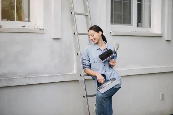 Schattig meisje staan in de buurt muur met reparatie tools — Stockfoto