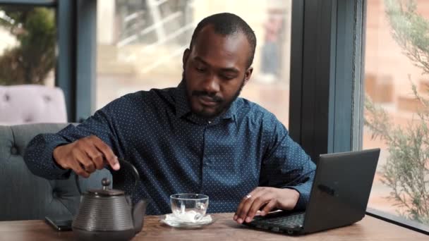 Бизнесмен удаленно работает с ноутбуком в кафе — стоковое видео