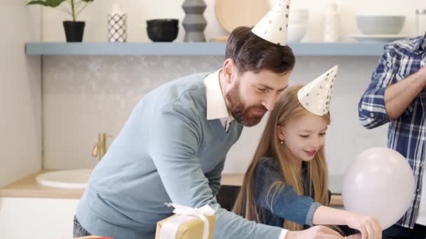 Far och dotter i födelsedagshattar förbereder sig för fest i köket — Stockvideo