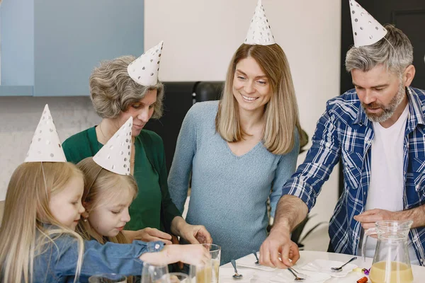 Family celebrating birthday of their grandmother in the kitchen