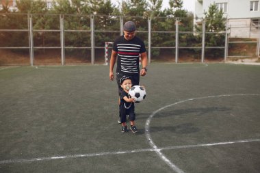 Babası ve küçük oğlu futbol oynuyorlar.