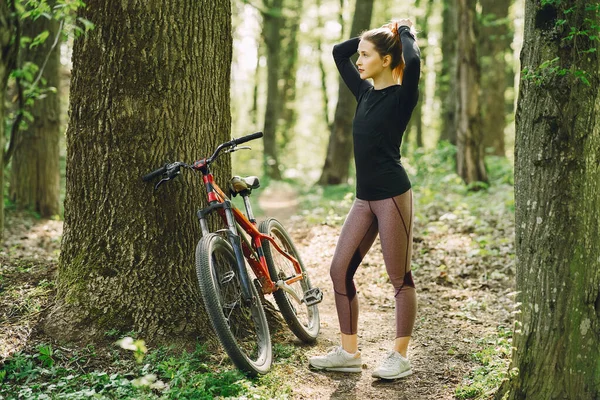 Žena na horském kole v lese — Stock fotografie