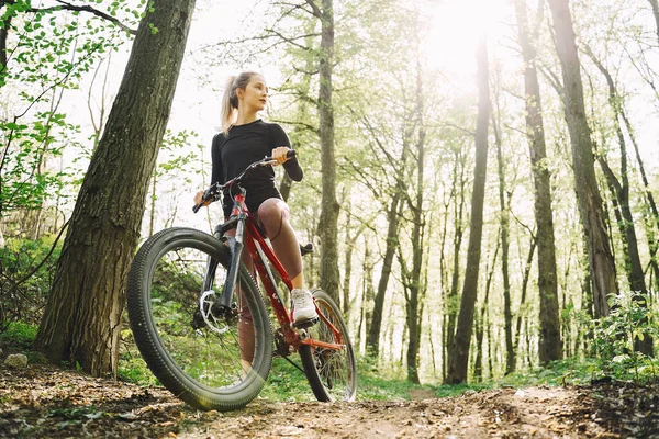 Kvinna rida en mountainbike i skogen — Stockfoto