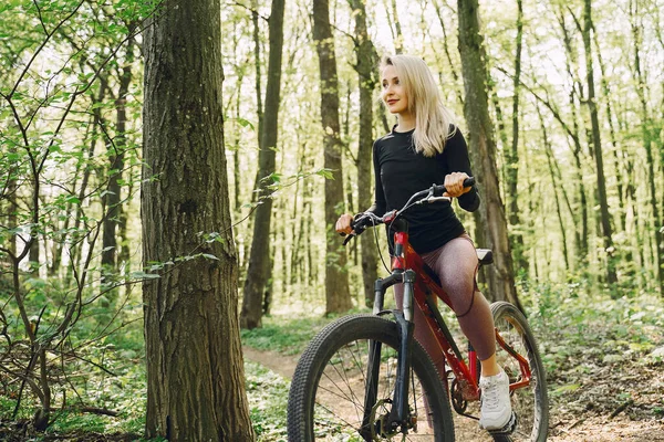 Frau mit Mountainbike im Wald unterwegs — Stockfoto