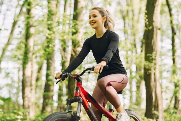 Frau mit Mountainbike im Wald unterwegs — Stockfoto