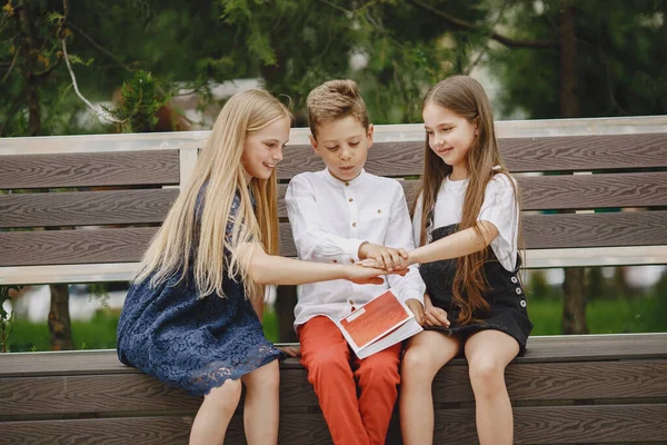 Niños felices sentados juntos cerca y sonriendo — Foto de Stock