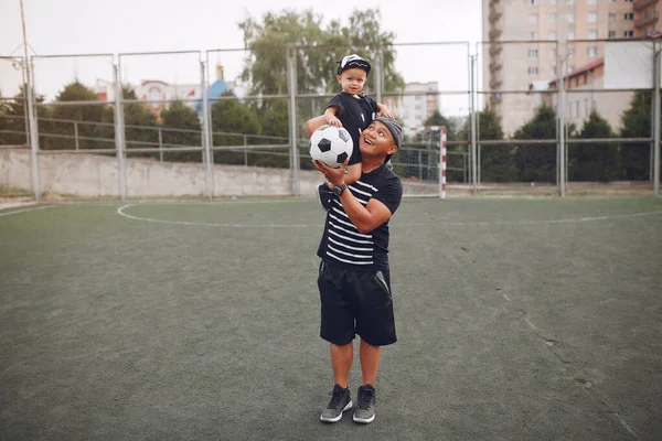 子供がサッカーをしている父親 — ストック写真