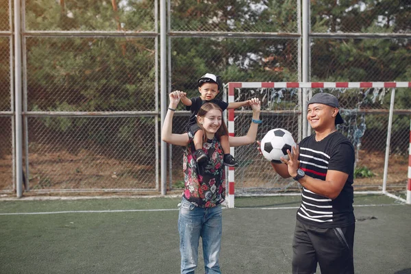 Küçük oğlu futbol oynayan bir aile. — Stok fotoğraf