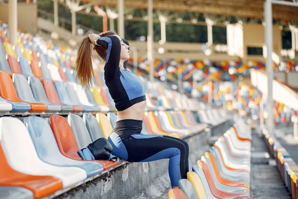 Sportowa dziewczyna w niebieskim mundurze stojąca na stadionie — Zdjęcie stockowe