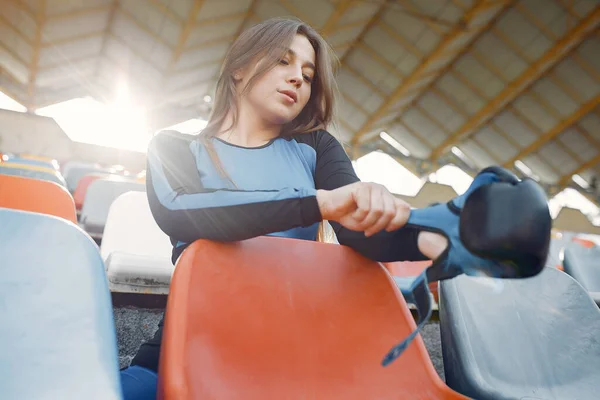 Спортивная девушка в синей форме стоит на стадионе — стоковое фото