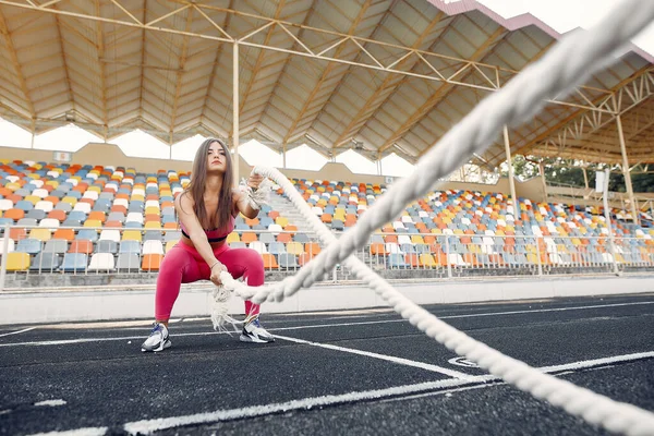 Menina de esportes em um treinamento uniforme rosa com corda no estádio — Fotografia de Stock