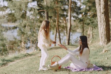 Kızıyla birlikte yaz ormanında zarif bir anne.