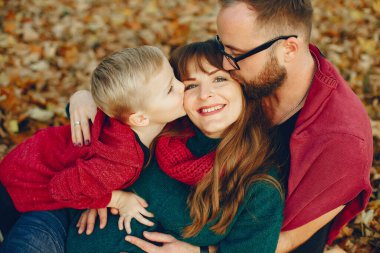 Sonbahar parkında küçük oğlu olan bir aile.