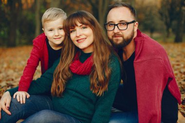 Sonbahar parkında küçük oğlu olan bir aile.