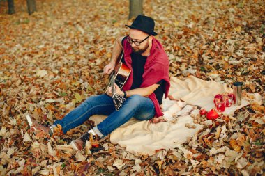 Sonbahar parkında oturan yakışıklı adam.