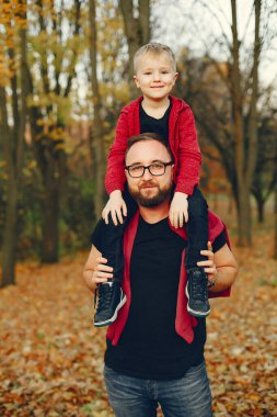 Sonbahar parkında oynayan sevimli bir aile.