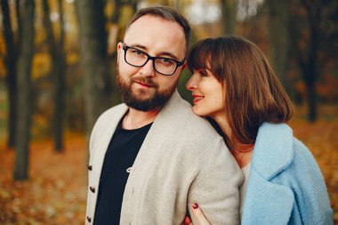 Zarif çift sonbahar parkında vakit geçiriyor.