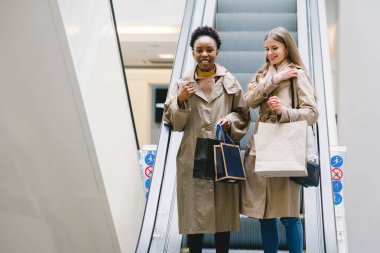 Alışveriş torbalarıyla gezen mutlu kızlar.