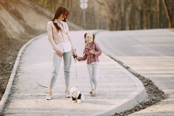 Moeder met dochter in een voorjaarsbos met hond — Stockfoto