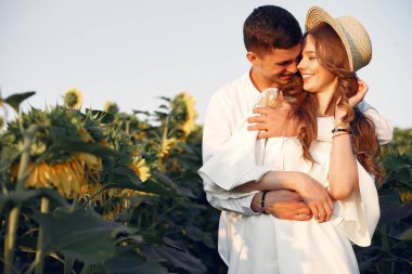 Tarlada kabarık ayçiçeklerinde güzel ve şık bir çift