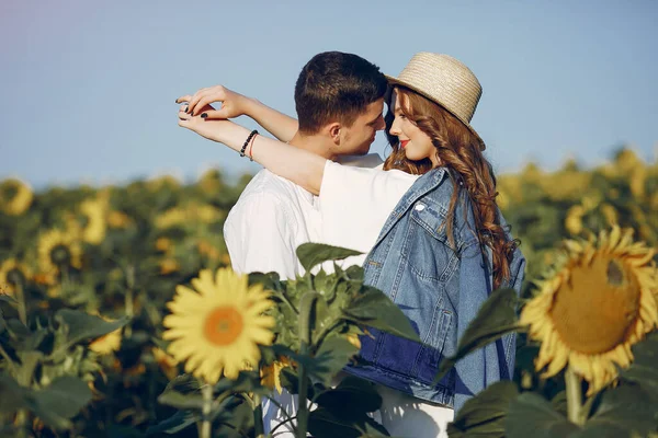 Beau et élégant couple dans un champ wirh tournesols — Photo