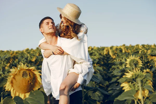 Belo e elegante casal em um campo girassóis wirh — Fotografia de Stock