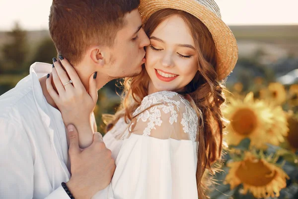 Gyönyörű és elegáns pár egy mezőn wirh napraforgó — Stock Fotó