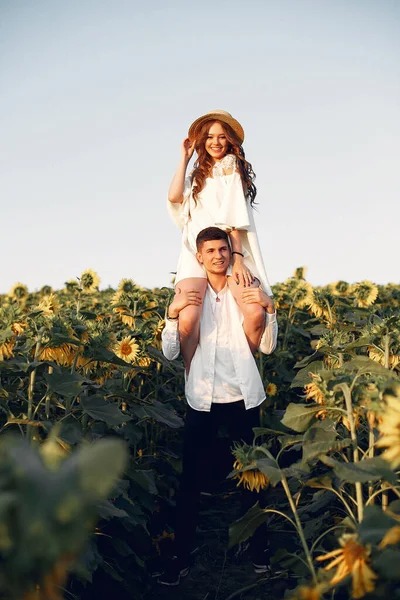 Vackra och eleganta par i ett fält wirh solrosor — Stockfoto