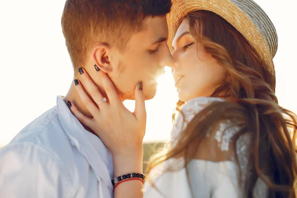 Beautiful and stylish couple in a field wirh sunflowers — Stock Photo, Image