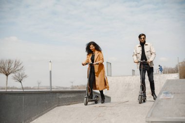 Şehirdeki arka planda mobiletleri olan ırklar arası genç bir çift.