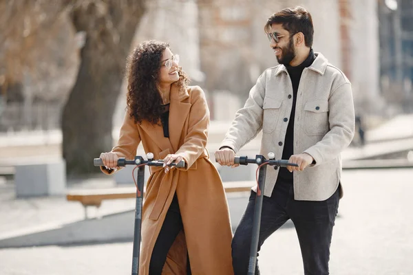 Interrazziale giovane coppia con scooter in città sfondo — Foto Stock