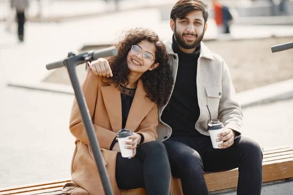 Exotisches junges Paar mit Roller im Hintergrund der Stadt — Stockfoto
