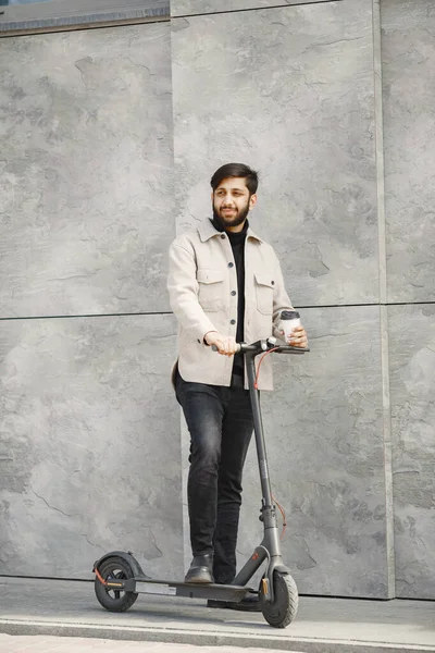 Hombre sonriente positivo montando un patinete scooter — Foto de Stock