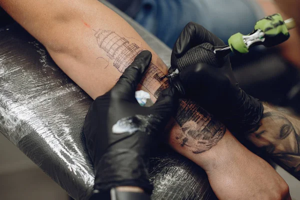 Homem fazendo uma tatuagem em um salão de tatuagem — Fotografia de Stock