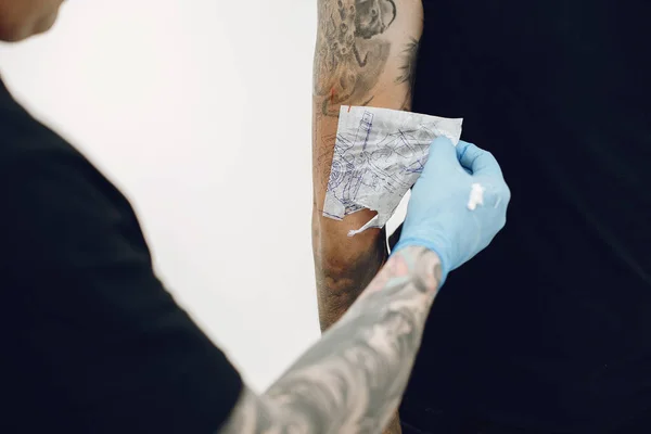 Hombre haciendo un tatuaje en un salón de tatuajes — Foto de Stock