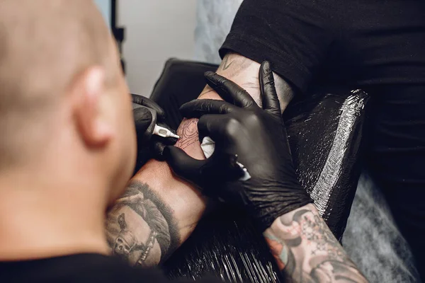 Man doing a tattoo in a tattoo salon — Stock Photo, Image