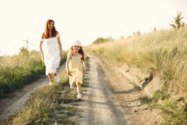 Anne ve kızı yaz tarlasında oynuyorlar.