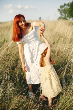 Anne ve kızı yaz tarlasında oynuyorlar.