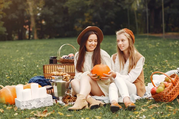 Meninas elegantes e elegantes sentadas em um parque de outono — Fotografia de Stock