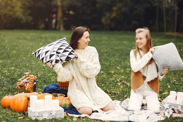 Ragazze eleganti ed eleganti sedute in un parco autunnale — Foto Stock