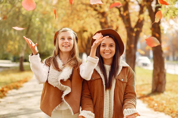 Elegante en stijlvolle meisjes in een herfstpark — Stockfoto