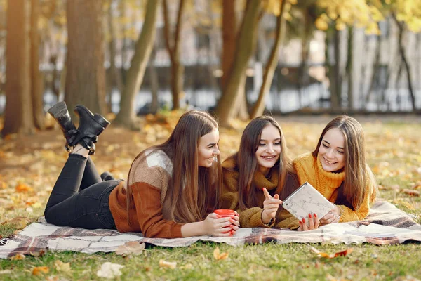 Ragazze sedute su una coperta in un parco autunnale — Foto Stock