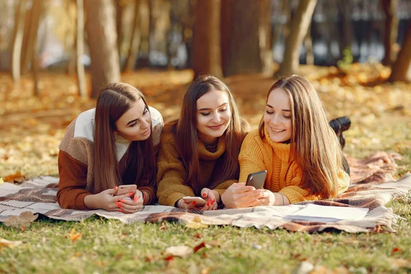 Sonbahar parkında battaniyede oturan kızlar — Stok fotoğraf